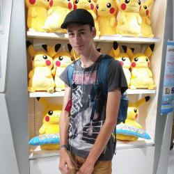 Zacharie devant les peluches Pikachu du Pokemon centre